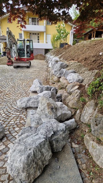 Felsblöcke setzen für die Hangmauer